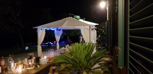 a table with a white umbrella at night at B&B Cervare in Montelupone