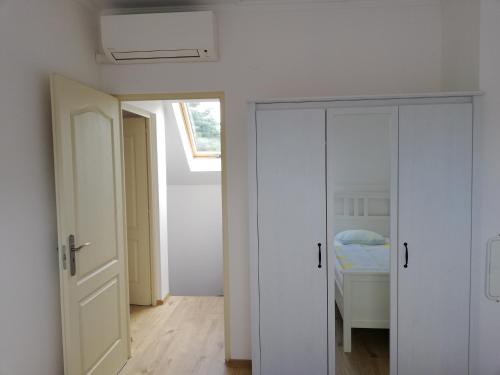 a room with white doors and a bedroom with a bed at Fenyves Ferienhaus 1 **** in Balatonfenyves