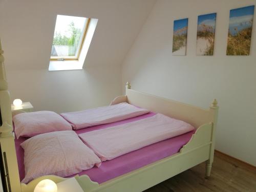 ein Bett mit rosa und lila Handtüchern darauf in der Unterkunft Fenyves Ferienhaus 1 **** in Balatonfenyves