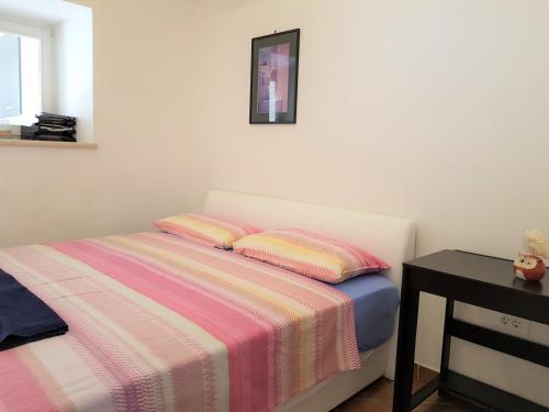 1 dormitorio con 1 cama con manta a rayas en Studios Mimoza, en Dubrovnik