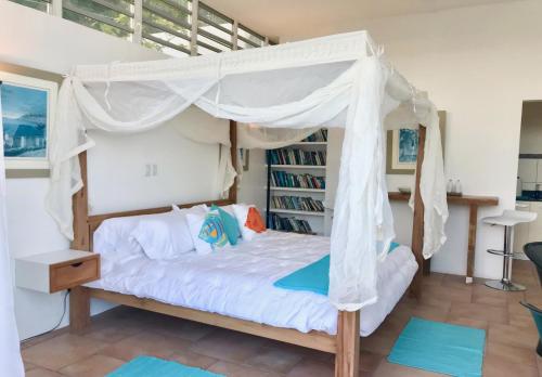 a bedroom with a bed with a canopy at Villa Cleavage in Simpson Bay