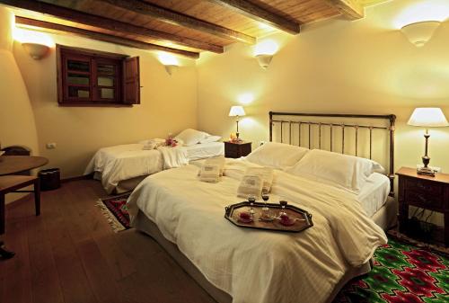 a hotel room with two beds with a tray on them at Archontiko Chioti in Leonidion
