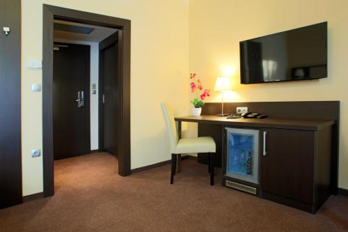 a room with a desk with a chair and a tv at Casino & Hotel ADMIRAL Ptuj in Ptuj