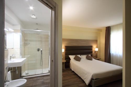 1 dormitorio con cama, ducha y lavamanos en "Il Viottolo" Rooms and Breakfast en Roccaraso