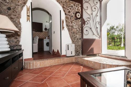 a kitchen with a tile floor and a hallway with a door at B&B La Mimosa in San Pietro