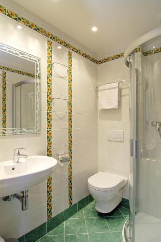 a bathroom with a toilet and a sink and a shower at Green Garden Hotel in Prague