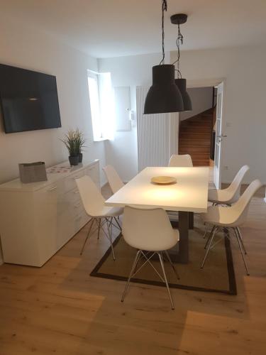 une salle à manger avec une table et des chaises blanches dans l'établissement Quartier "Zur Alten Apotheke", à Brackenheim