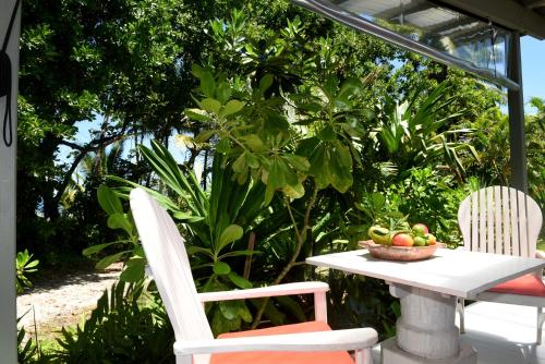 - une table et des chaises avec un bol de fruits dans l'établissement Sejala Beach Huts, à Mission Beach