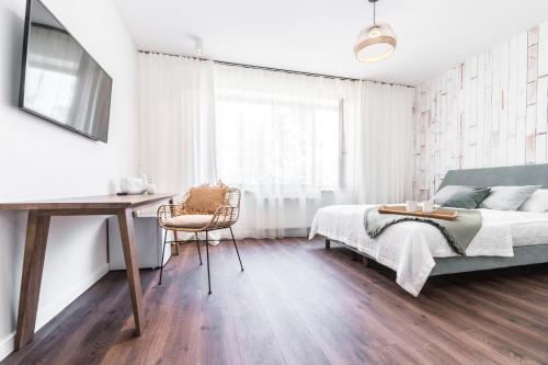 a bedroom with a bed and a table and a desk at Tamara Suites & Apartments in Jūrmala