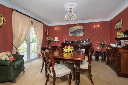 a dining room with red walls and a table and chairs at Friars Quarter House in Ballinrobe