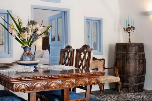 a dining room with a table and a wooden barrel at Abelis Canava Luxury Suites in Vóthon