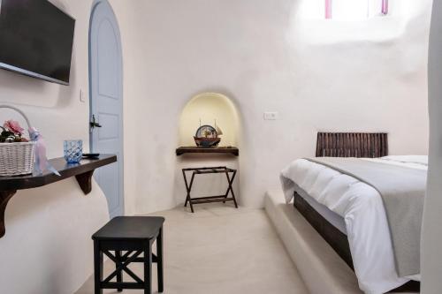 a white bedroom with a bed and a table at Abelis Canava Luxury Suites in Vóthon
