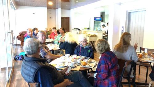 a group of people sitting at tables eating food at Casa De Luz Hotel in Machu Picchu