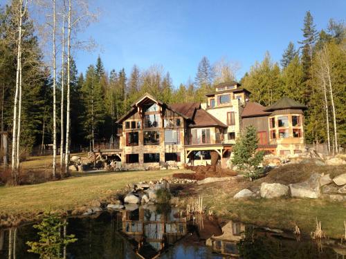 a large house with a pond in front of it at Talus Rock Retreat in Sandpoint