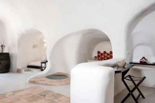 a room with white walls and a table and a chair at Abelis Canava Luxury Suites in Vóthon