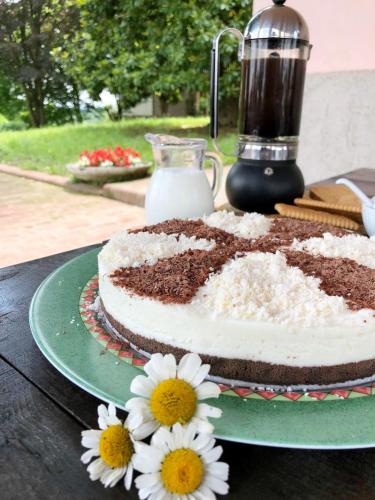 a chocolate cake sitting on a table with flowers at B&B Locanda dei Tigli in Serravalle dʼAsti