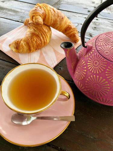 a cup of tea and a croissant on a table at B&B Locanda dei Tigli in Serravalle dʼAsti