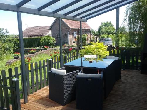 a patio with a blue table and chairs on a deck at Le Havre de Samara in Nurlu