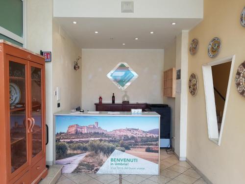 a large screen television in a room with a mountain at Hotel Il Cammino Di Francesco in Bastia Umbra