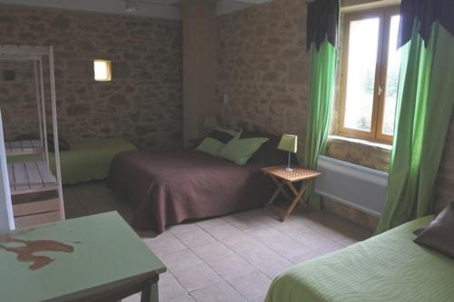 sypialnia z 2 łóżkami i oknem z zielonymi zasłonami w obiekcie jour aprés jour au mas d'alzas chambres d hotes et gite w mieście Serviers-et-Labaume