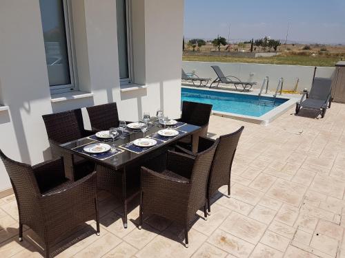 a dining room table and chairs and a swimming pool at T&E Villa in Larnaca