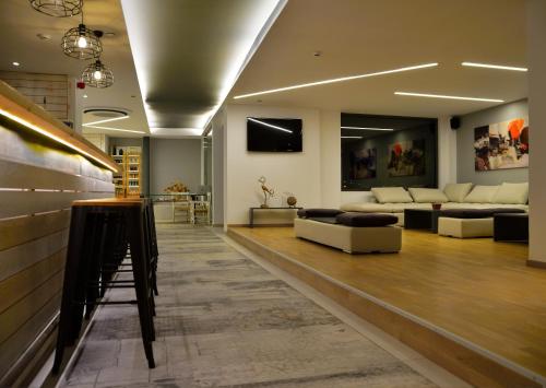 a large living room with couches and a bar at Meliti Hotel (Adults Only) in Agios Nikolaos
