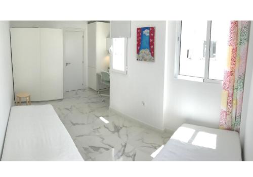 um quarto branco com paredes brancas e pisos em mármore em New central 2BR apartment 100m-to-beach free parking em Fuengirola