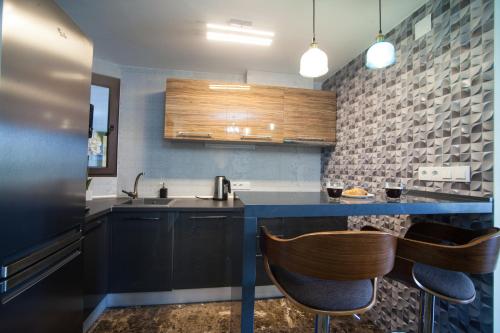 uma cozinha com um lavatório e duas cadeiras em Apartment on Bautista Lafora 2 em Alicante