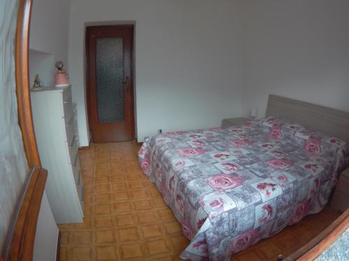 a bedroom with a bed with a floral bedspread at Gli Ulivi di Nesso in Nesso