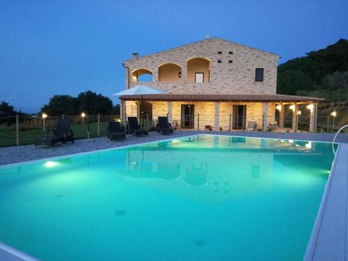 a villa with a swimming pool in front of a building at B&B CasalFarano in Cupra Marittima