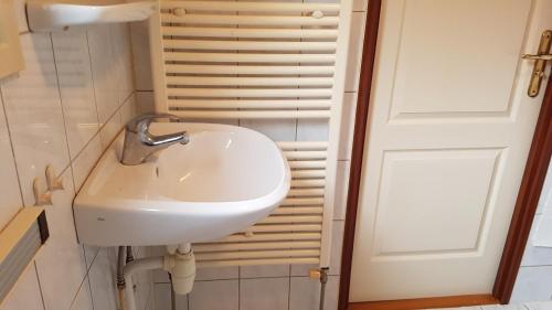 um lavatório branco numa casa de banho ao lado de uma porta em Deluxe Holiday Home em Putten