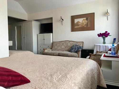 a bedroom with a large bed and a couch at Hotel Wenus in Kazimierz Dolny