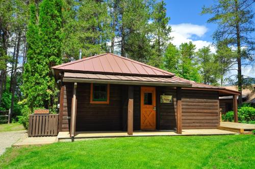 a small wooden cabin with a red roof at Glacier Homestead in Coram
