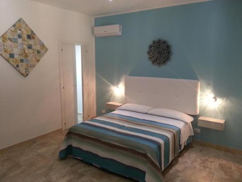 サン・ヴィート・ロ・カーポにあるHoliday Homenzaの青い壁のベッドルーム1室