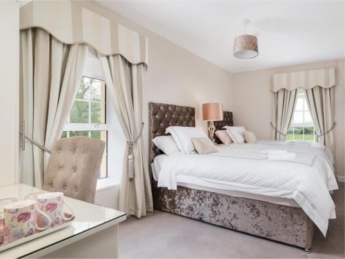 a white bedroom with a large bed and a window at Friars Quarter House B&B in Ballinrobe