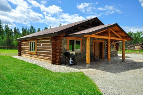 a log cabin with a grill in a yard at Glacier Homestead in Coram
