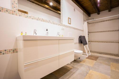 a bathroom with a white vanity and a toilet at Molino de Saladilla in Coín