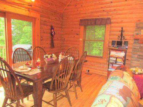 a dining room with a table and chairs in a cabin at Alpine Log Cabin in Boone