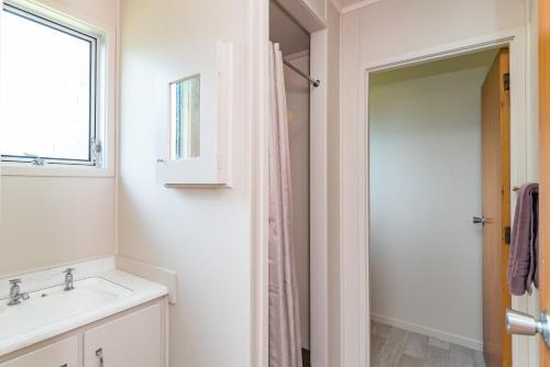 
a bathroom with a shower, sink, and toilet at Te Tiriti Units in Paihia
