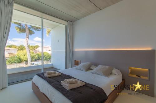 una camera da letto con un letto grande e una grande finestra di Platja de Muro - 2183-30 Mallorca a Muro