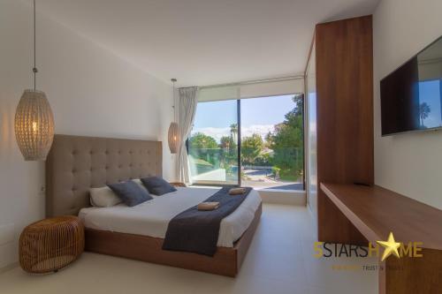 Un dormitorio con una cama grande y una ventana grande. en Platja de Muro - 2183-24 Mallorca, en Playa de Muro