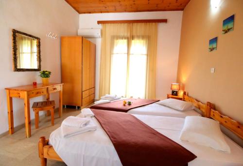 Perivólion的住宿－Romeo & Juliet，一间卧室设有两张床、一张桌子和一个窗口。