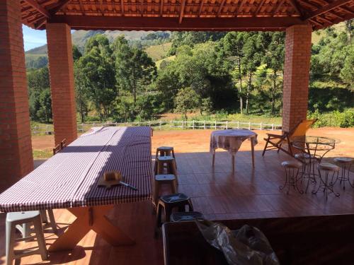 a wooden deck with a table and chairs on it at Sítio e Haras Alagoense in Alagoa