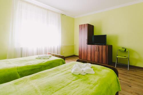 モーラハロムにあるLak6 Apartmentのベッド2台とテレビが備わるホテルルームです。