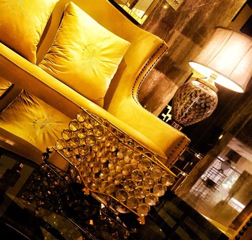 a living room with a yellow couch and a lamp at Lumiere Des Etoile in Kuwait