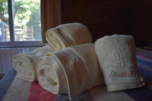 a pile of towels on top of a bed at Cabañas Latitud 38.15 in Sierra de la Ventana