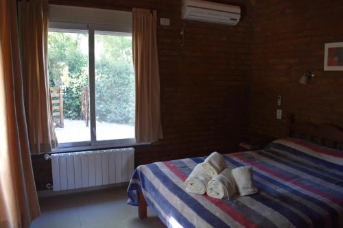 a bedroom with a bed with towels on it at Cabañas Latitud 38.15 in Sierra de la Ventana