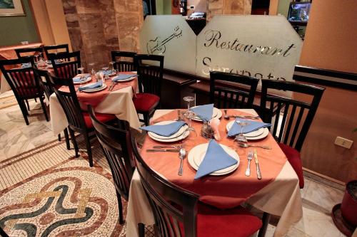 a restaurant with tables and chairs with plates and napkins at Hotel Regency in Korçë