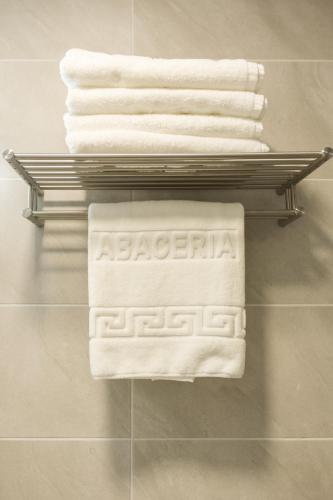 a towel rack with white towels on it in a bathroom at Abacería in Toledo