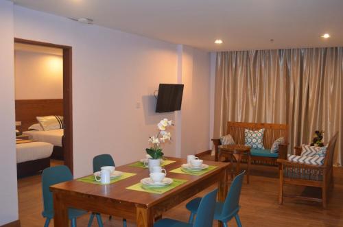 a living room with a table and chairs and a bedroom at TD Mutiara Hotel Semporna in Semporna